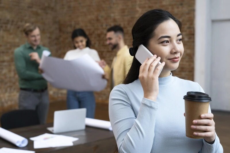 ผู้หญิงถือแก้วกาแฟ คุยโทรศัพท์